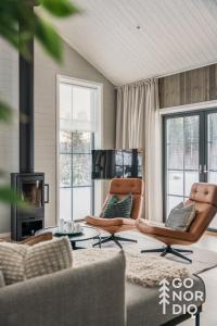 a living room with two chairs and a fireplace at The Black Bear Lodge in Tällberg +49 photos