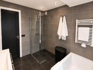 a bathroom with a shower and a bath tub at Cozy apartment in authentic farmhouse in Gouda +13 photos