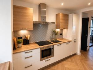 a kitchen with white cabinets and a sink at Cozy apartment in authentic farmhouse in Gouda
