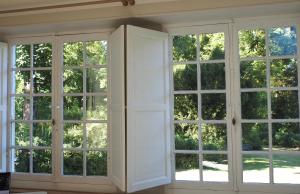 a room with large windows with white doors at APPART en THÈSE Appartement climatisé Accessible PMR Proche Dijon et CEA Valduc in Moloy