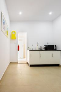 an empty room with a kitchen with white cabinets at Sleep in Centre - Old Town in Aveiro