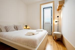 a white bedroom with a large white bed and a window at Sleep in Centre - Old Town in Aveiro