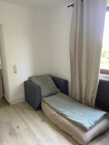 a small bed in a room with a window at Gemütliche Ferienwohnung direkt am Waldrand in Dörentrup