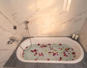 a bath tub filled with sprinkles in a bathroom at Heera Lodge Kasauli By Evening Sky Hotel in Kasauli