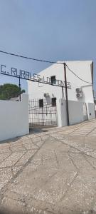 a white building with a sign on top of it at Casas Rurales Los Montes in La Corte