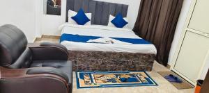 a bedroom with a bed with a chair and a chair at Hotel Kanha palace in Lucknow +15 photos