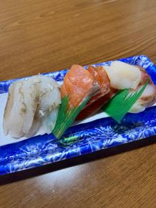 two different types of sushi on a blue plate at ゲストハウス潮目 in Shibetsu