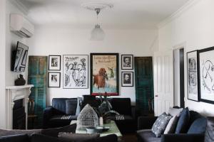 a living room with couches and posters on the walls at Piccadilly House Daylesford in Daylesford