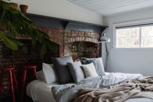 a bedroom with a bed and a brick wall at Piccadilly House Daylesford in Daylesford