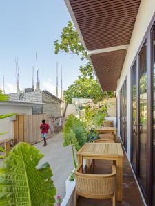an outdoor patio with tables and chairs and plants at Kinan Sentral in Fulidhoo