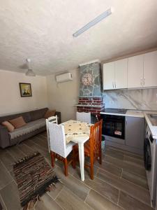 a kitchen and living room with a table and chairs at Vila Mulla in Ksamil +37 photos