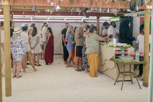a group of people standing around a food stand at Kinan Sentral in Fulidhoo
