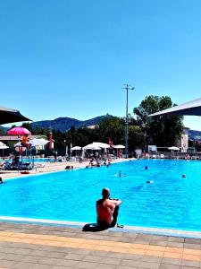 a man sitting in front of a swimming pool at Brvnara Vršac in Vršac