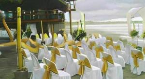 a row of white chairs with yellow bows at Apple Tree Resort & Hotel in Opol +218 photos