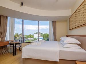 a bedroom with a large bed with a large window at Kinan Sentral in Fulidhoo +86 photos