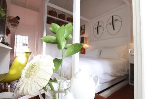 a bedroom with a bed and a vase with a flower at Senhora do Cabo Meco Homy Holidays in Sesimbra