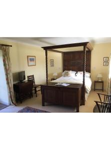 a bedroom with a large canopy bed and a desk at The Annex - Easter Arr in Auldearn