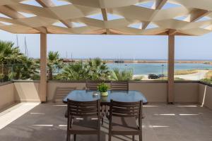 a patio with a table and chairs and a view of the ocean at Amara Cove Adults Only by Estia in Malia