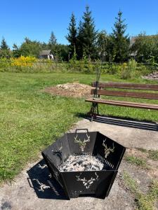a fire pit sitting next to a park bench at Pensjonat i domki Kresy in Pogorzelce +47 photos