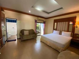 a bedroom with a large bed and a couch at My House in Surin