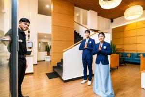 two men and a woman standing in a lobby at Sparrow Elements Boutique 2 min walk To Mg Marg in Gangtok