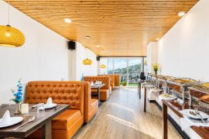 a restaurant with couches and tables and windows at Sparrow Elements Boutique 2 min walk To Mg Marg in Gangtok