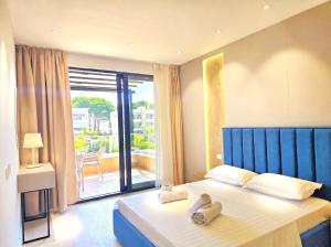a bedroom with a bed with two towels on it at Azure Garden Villa 317 in Lalzit Bay