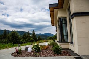 a house with a flower bed in front of a window at Sungora sun&ski resort in Slavske