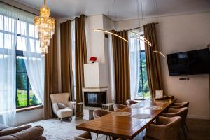 a living room with a table and chairs and a chandelier at Sungora sun&ski resort in Slavske