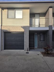 a house with a garage door in front of it at Private Room with Queen Bed & Bathroom in Bellbird Park