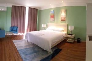 a bedroom with a white bed and green walls at Tinian diamond hotel in Tinian International Airport