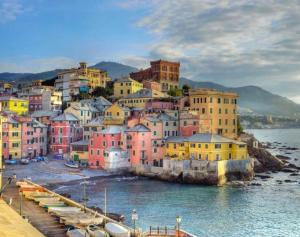 a town with colorful houses and boats in the water at Putti giocosi in Genoa