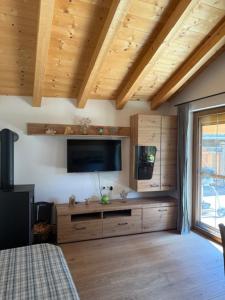 a living room with a tv and a bed and a room with at Ferienwohnung Sonnheim Alpbachtal Card inklusive in Alpbach