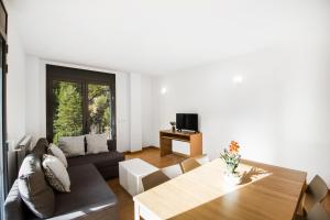 a living room with a couch and a table at Font del Ferro Apartments in El Tarter