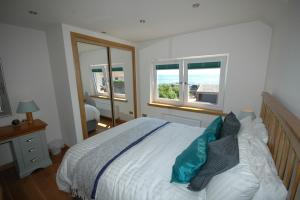 a bedroom with a bed and two windows at The Coopers View in Cellardyke