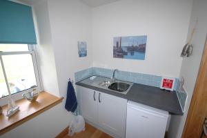 a small kitchen with a sink and a window at The Coopers View in Cellardyke +39 photos