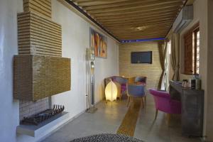 ein Wohnzimmer mit einem Kamin und einem TV in der Unterkunft Riad Kalaa 2 in Rabat