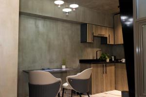 a kitchen with white chairs and a counter top at TUNA Hiriketiya - Luxury Resort & Pool Retreat in Hiriketiya