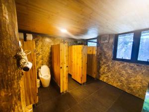 a bathroom with wooden walls and a toilet at Phủ Homestay Sapa in Sapa