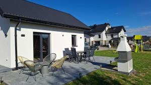 a patio with chairs and a table and a building at Domek na Ogrodowej in Tylicz