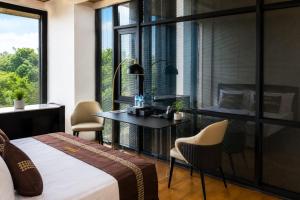 a bedroom with a bed and a desk and a window at TUNA Hiriketiya - Luxury Resort & Pool Retreat in Hiriketiya +22 photos