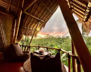 a balcony of a hut with a view of the jungle at Rafka Bamboo Valley in Seribatu +14 photos