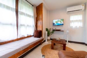 a living room with a bed and a large window at Mango House Studio -Pai in Mae Hong Son