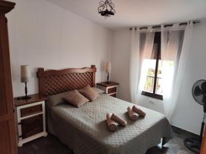 a bedroom with a bed with two pairs of shoes on it at Casas Rurales Los Montes in La Corte