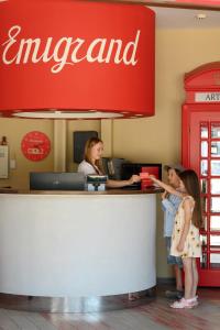 two girls standing at the counter of an american restaurant at Emigrand Art Hotel in Uzhhorod
