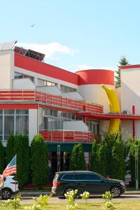 a car parked in front of a building with an american flag at Emigrand Art Hotel in Uzhhorod