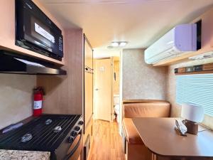 a small kitchen with a stove and a microwave at Best RV-Camper To Visit NYC-Hot Tub-Free Parking in Hillside