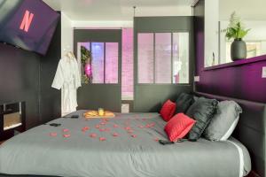 a bedroom with a large bed with red pillows at Dalikyda La Tentation Jacuzzi Cinéma élégant in Le Havre +44 photos