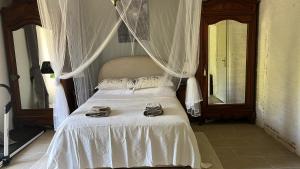 a bedroom with a white bed with shoes on it at Le Domaine in Lignac
