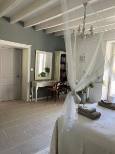 a bedroom with a bed with a white canopy at Le Domaine in Lignac